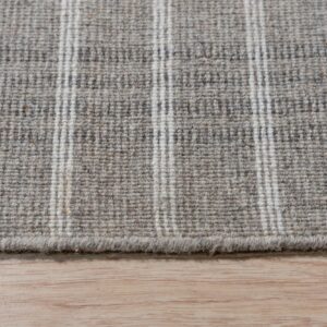 A woven gray and cream striped rug texture rests on light wood flooring.