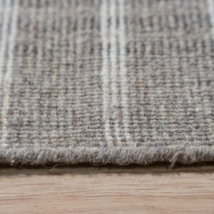 Textured, low-pile gray rug with subtle light stripes rests on a light brown wooden floor.