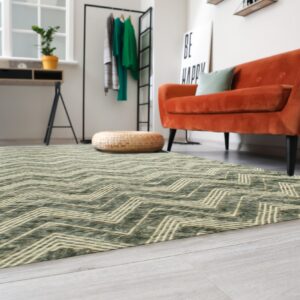 Textured green rug with beige zig-zag pattern anchors a brightly lit room with a burnt orange couch.