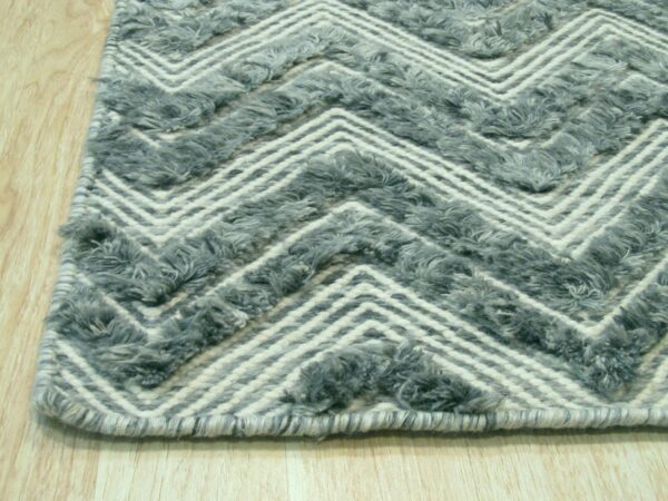 Textured gray and off-white zigzag rug detail visible against light wood flooring.