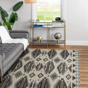A cream rug with gray and brown geometric patterns covers wood floors beneath a gray sofa.