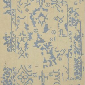 Geometric light blue motifs and fragmented borders are scattered across a cream flatweave rug.