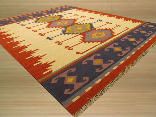 Flat-weave rug featuring a cream central field, multicolored geometric motifs, and a dark indigo and rust border.