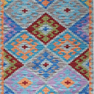 A vibrant flatweave rug displaying geometric diamond patterns in shades of blue, orange, purple, and gray.