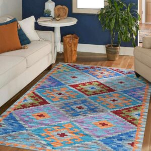 Brightly patterned geometric rug in blue, purple, red, and orange anchors a living room with dark blue walls.