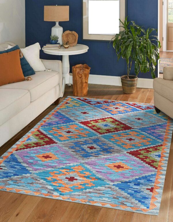 Brightly patterned geometric rug in blue, purple, red, and orange anchors a living room with dark blue walls.
