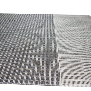 Striped flatweave rug featuring a bold dark gray section next to a lighter off-white striped section.