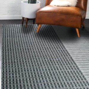 Black and white striped rug with a diagonal color-block pattern beneath a brown leather chair on dark wood flooring.