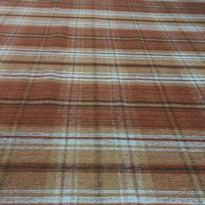 A rust and tan plaid rug with a flat texture sits on light plank flooring.