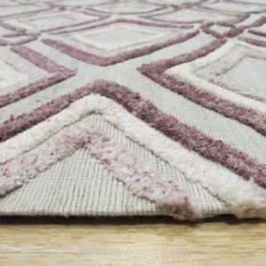 Close-up shows a light gray rug with raised loop pile texture in white and mauve geometric patterns on wood flooring.