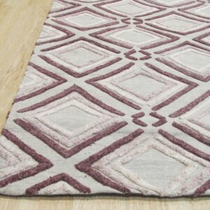 Raised purple and pink diamond patterns cover a light grey rug lying on blonde wood flooring.
