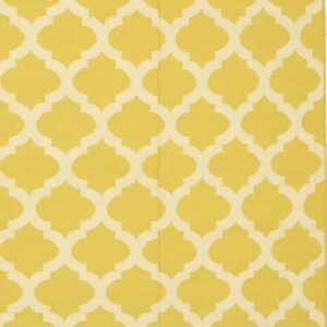 Flatweave rug with a bright yellow and cream geometric quatrefoil pattern.