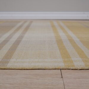 Low-pile yellow, cream, and tan plaid rug rests on light wood plank flooring.