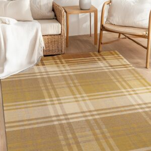 Gold and beige plaid area rug on wood flooring next to a wicker chair and sofa.