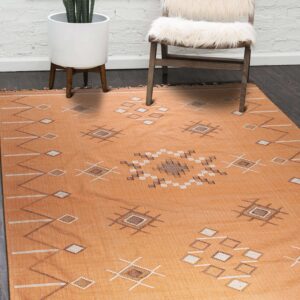 Terracotta flatweave rug featuring diamond motifs lies on dark wood flooring near a white fluffy chair.