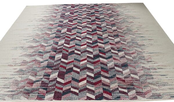 Flat-weave rug featuring a central red and blue chevron design fading out to a cream border.