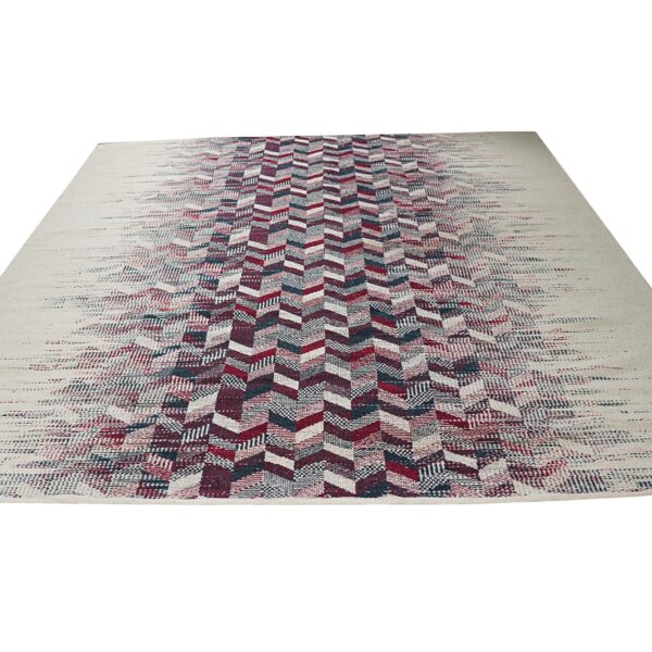 Cream rug featuring a central fading chevron pattern in burgundy, teal, and off-white colors.