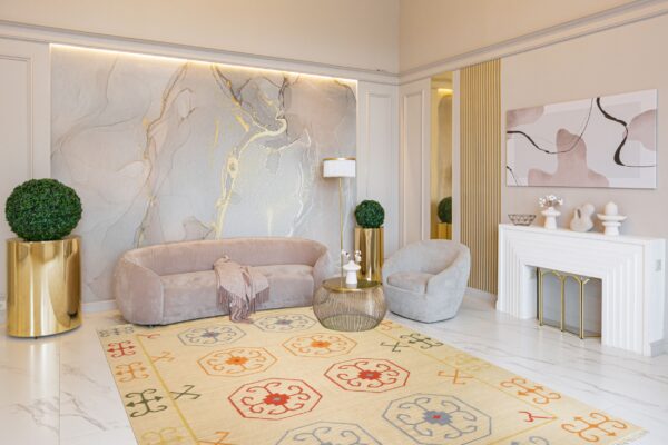 Beige flat weave rug with colorful geometric medallions defines a contemporary living room with velvet seating.