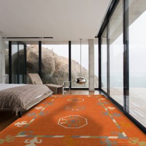 Bright orange flatweave rug with geometric patterns on dark wood floors in a modern bedroom with large glass windows.