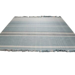 Light blue flatweave rug with multiple horizontal cream and slate blue stripes and fringed ends.