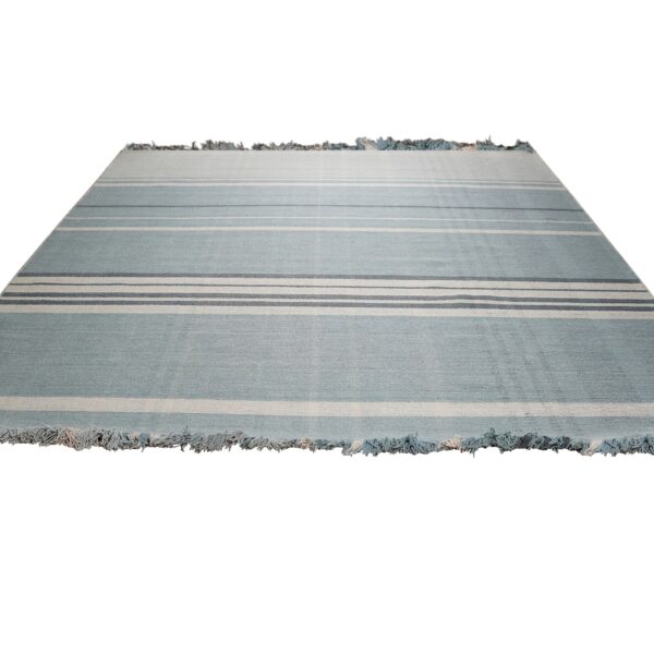 Light blue flatweave rug with multiple horizontal cream and slate blue stripes and fringed ends.