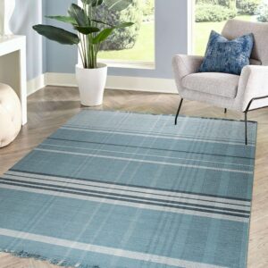 Teal and gray plaid rug with fringe ends on herringbone wood floors near a light gray chair.