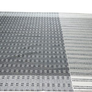 Gray and white low-profile rug with geometric patterns in contrasting dark and light vertical blocks.