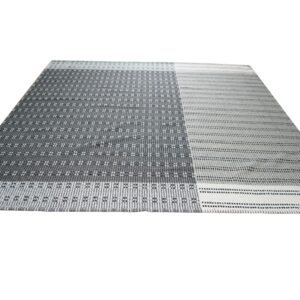 Gray and white flatweave rug with a segmented geometric pattern incorporating dots, diamonds, and stripes.