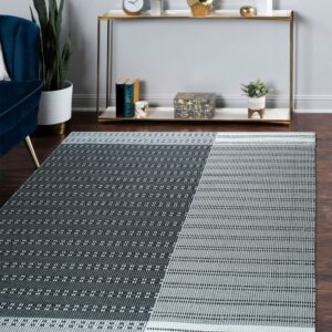 Charcoal and light gray rug with geometric dot patterns on hardwood floors near a blue chair and console table.