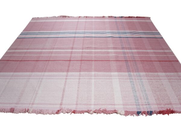 Pink and white flatweave rug with a plaid stripe design and short fringe on the ends.
