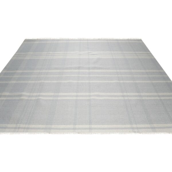 Light gray flatweave rug featuring thin cream stripes that form a subtle plaid pattern.