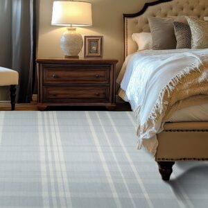 Plaid blue and cream rug placed beside a dark wood nightstand and upholstered bed in a warm bedroom.
