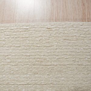 A textured light beige rug with thick horizontal loops lies on pale, reflective wood flooring.