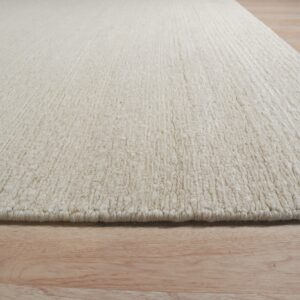 Cream-colored rug featuring a chunky textured pile resting on light wood flooring.