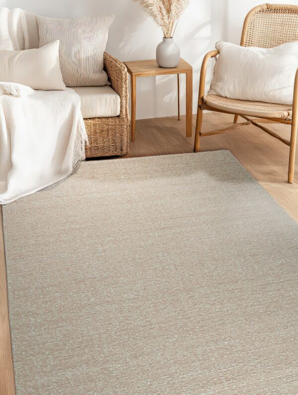 Textured beige rug placed on light wood flooring between wicker seating and a small wooden side table.