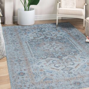 Blue traditional low-pile rug with copper accents beneath a white armchair and potted plant.