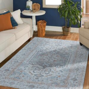 A blue and rust traditional rug anchors a living room with a cream sofa and navy wall.