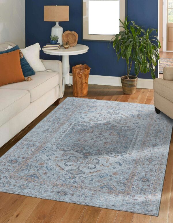 A blue and rust traditional rug anchors a living room with a cream sofa and navy wall.