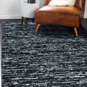 A black and light blue rug with a textured horizontal pattern sits beneath a brown leather armchair.