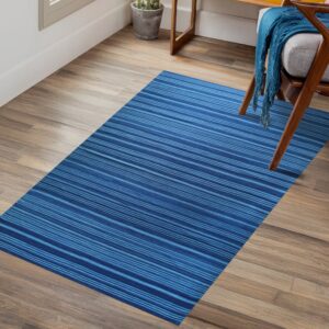 Blue striped rug on wood plank flooring next to a mid-century style wooden chair with a gray cushion.