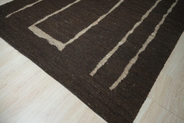 Dark brown low-pile rug with thick light beige geometric lines rests on pale wood flooring.