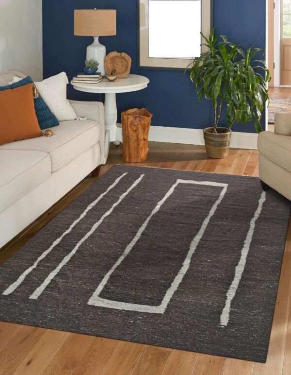 Dark heathered rug featuring light gray abstract stripes and a frame pattern grounds a blue living room.