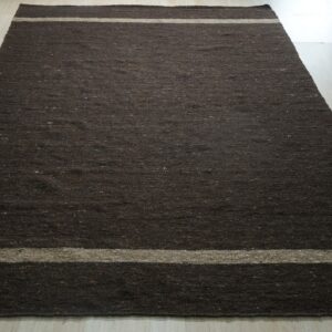 Rectangular dark brown, low-pile rug featuring light tan stripes on pale wood plank flooring.