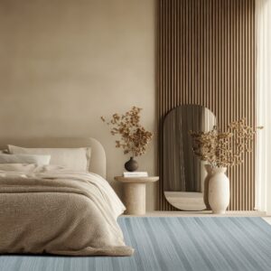 A dusty blue striped rug anchors a serene bedroom with beige walls and textured wood paneling.