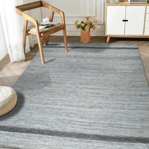 A low-pile gray striated rug with a dark band anchors a bright room with wood furniture.