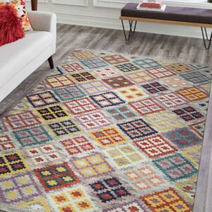 Brightly colored rug with geometric squares and diamonds on gray flooring near a white couch.