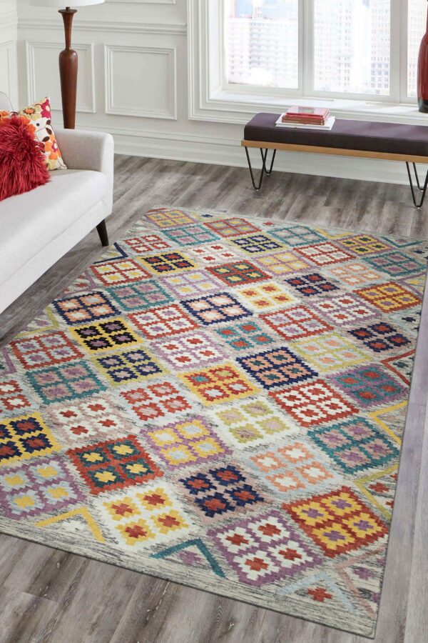 Brightly colored rug with geometric squares and diamonds on gray flooring near a white couch.