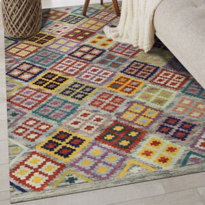 A low-pile rug with colorful diamond patterns rests on light wood floors beside a sofa and rope basket.