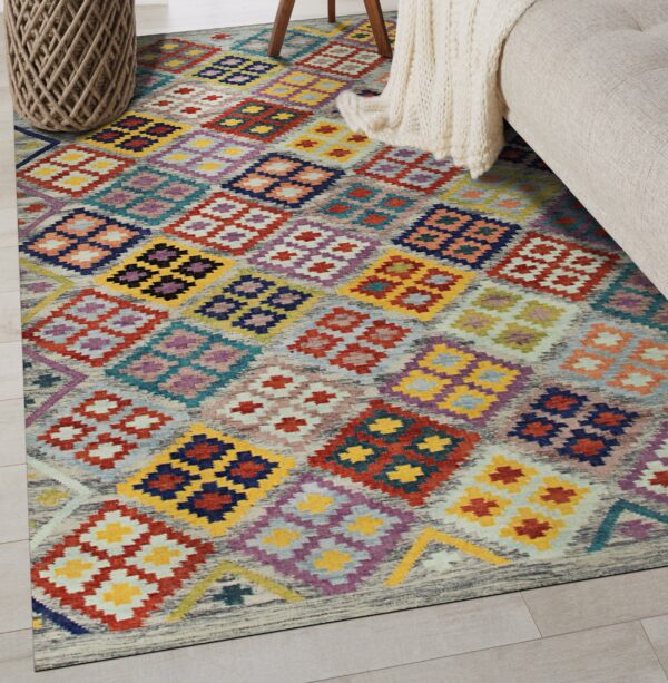 A low-pile rug with colorful diamond patterns rests on light wood floors beside a sofa and rope basket.
