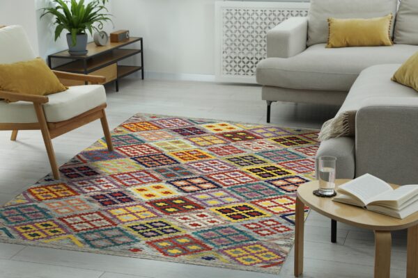 A colorful geometric diamond pattern rug sits on light wood flooring in a modern living room.